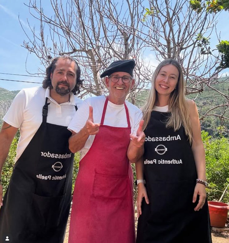 Equipo de experiencia paella valenciana: Julieta, Arturo y Rafa en finca rural valenciana rodeados de naranjos