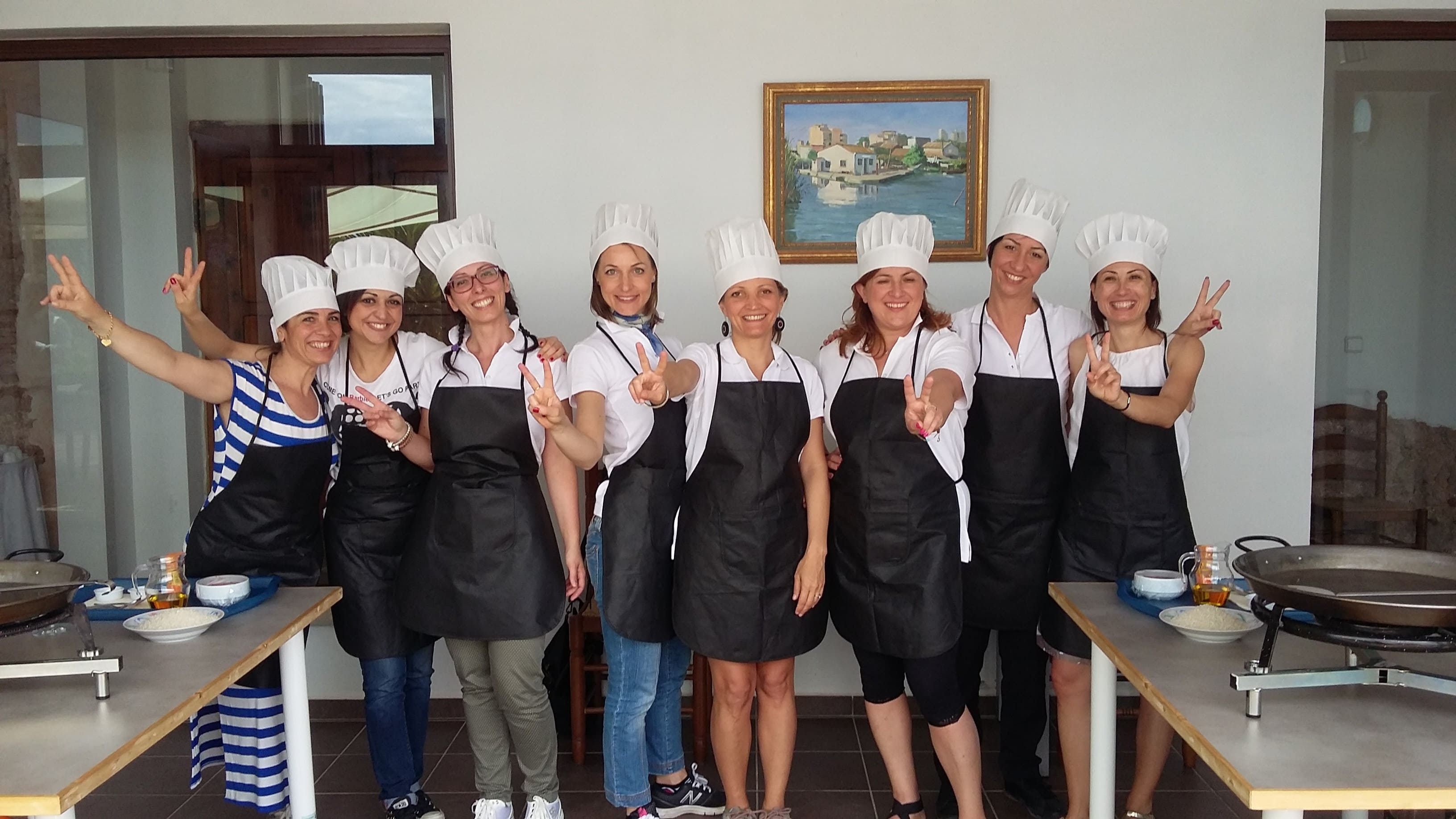 Familia cocinando paella valenciana juntos en experiencia gastronómica rural valenciana con productos de la huerta